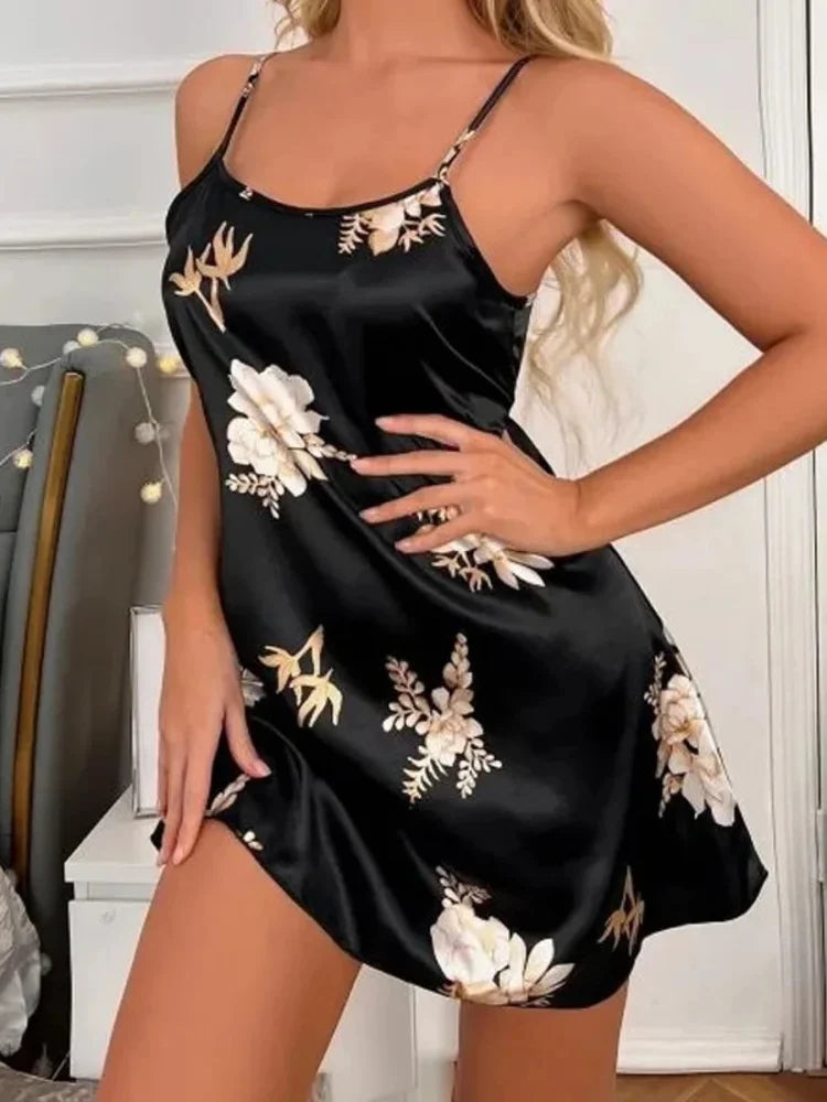 Woman wearing a black satin floral nightgown with adjustable straps, hand on hip, standing indoors