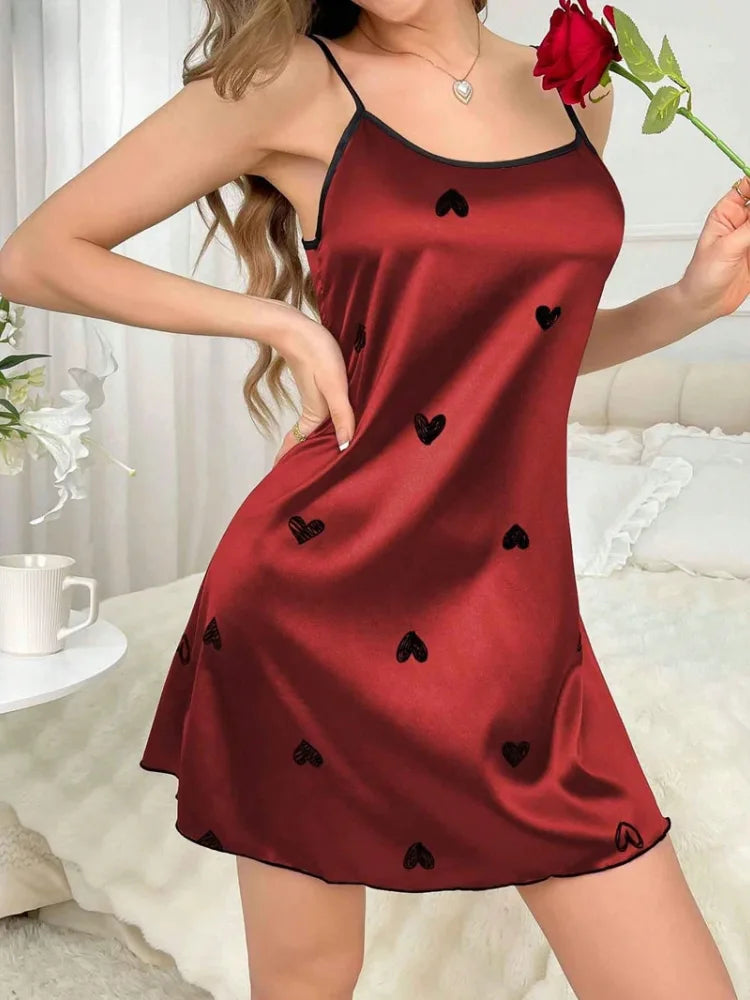 Burgundy satin mini nightgown with black heart print and spaghetti straps, front view, model holding red rose