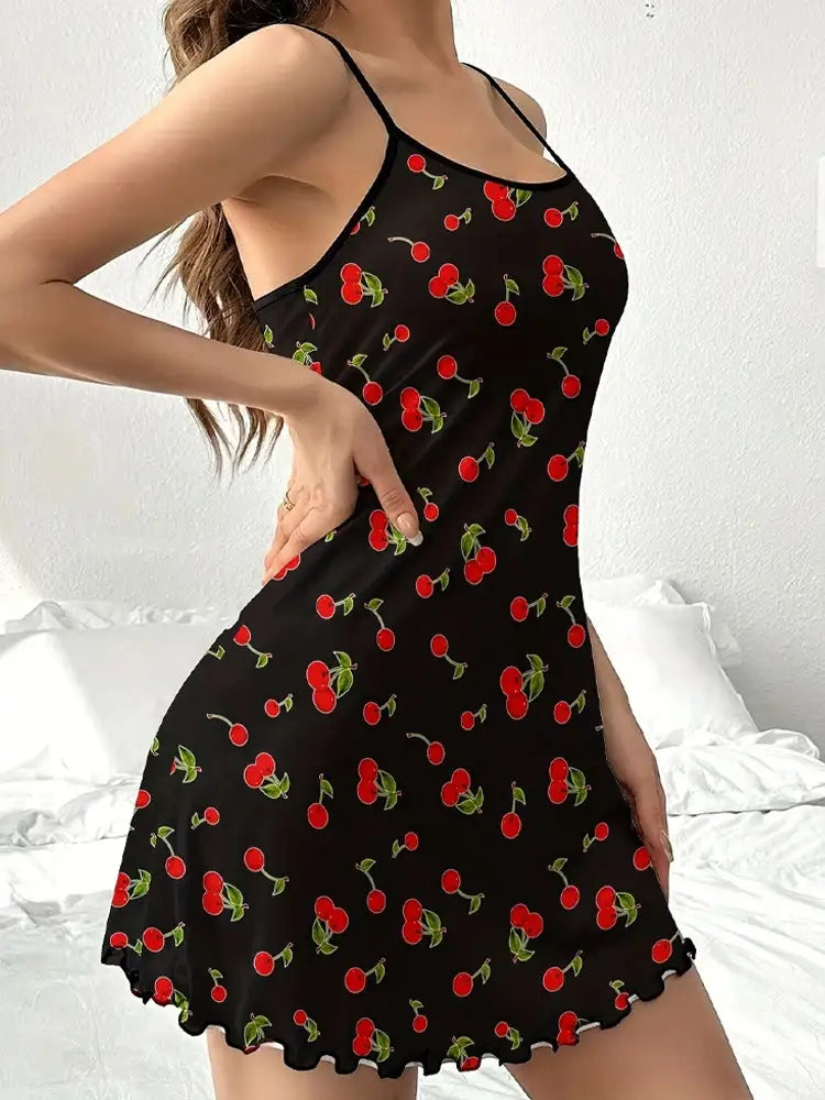 Woman wearing black mini nightgown with red cherry print, hand on hip, side view