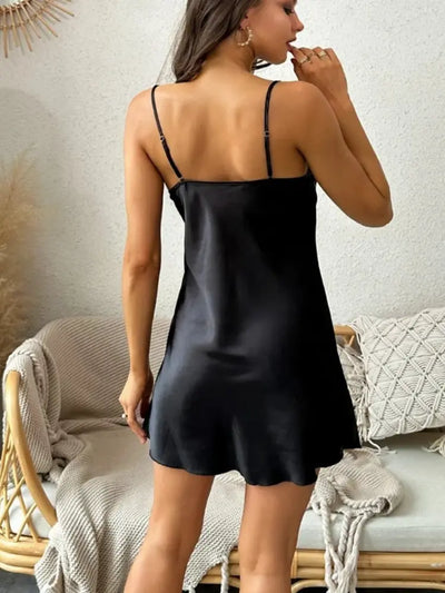 Black satin mini nightgown showing open back and adjustable strap hardware, rear view