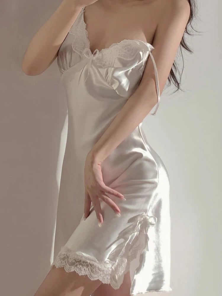 Ivory satin nightgown with lace V-neckline, center bow, and adjustable tie straps, close-up side view