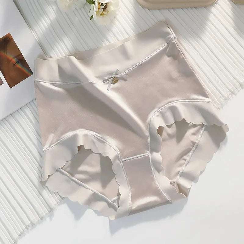 Beige mid-rise satin panties with scalloped hem and small bow detail, flat lay on white surface