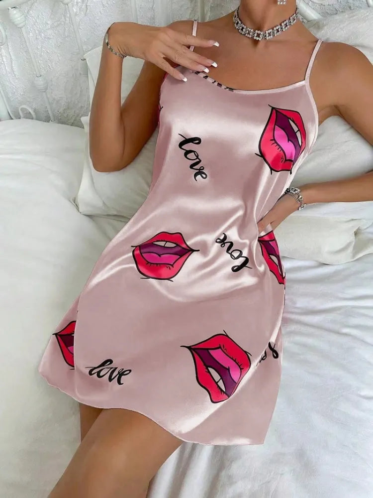 Blush pink satin mini nightgown with red lip print and love script worn in bed