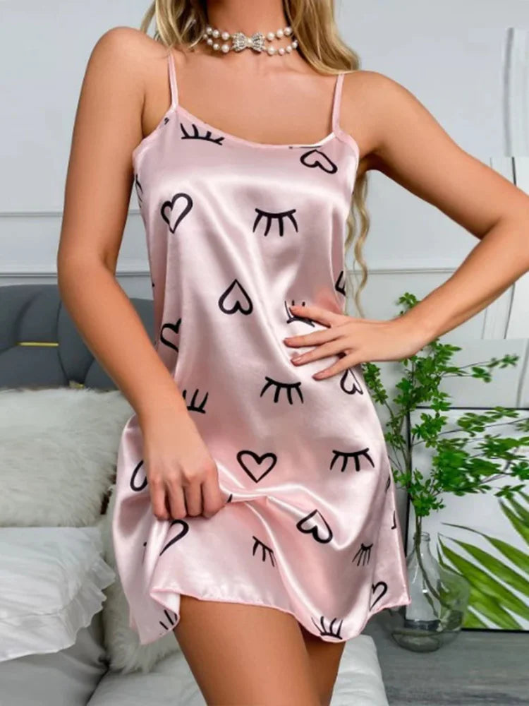 Pink satin mini nightgown with heart and closed-eye lash print, adjustable spaghetti straps, scoop neckline