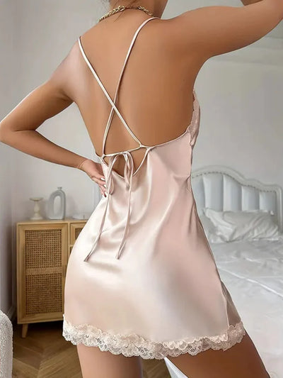 Back view of a champagne satin nightgown showing crossed spaghetti straps tied at the lower back, fully open spine