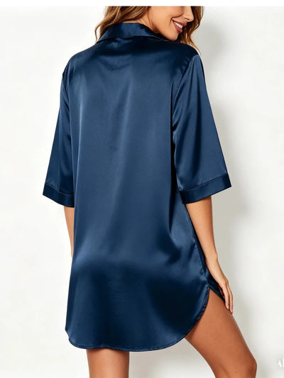 Back view of navy satin nightgown showing elbow-length sleeves and curved hem on female model