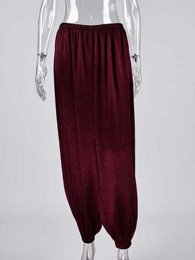 Burgundy wide-leg satin pants with elastic waist and gathered ankle cuffs on mannequin